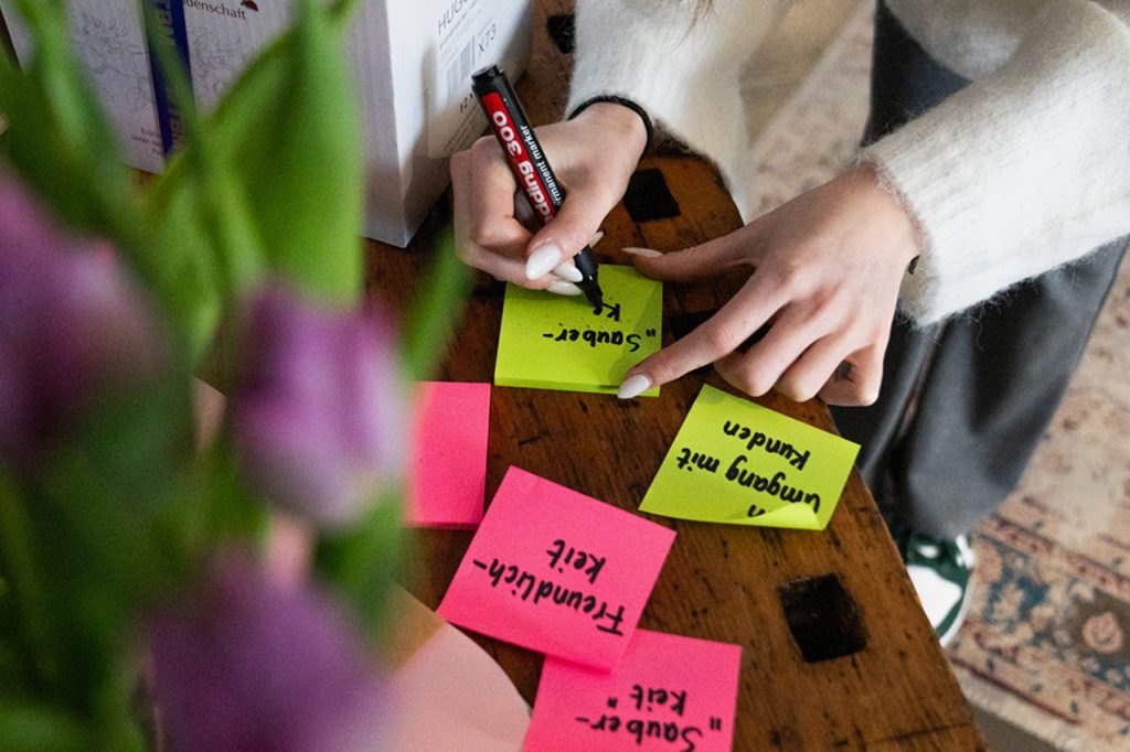 Person, die Post-It-Notizzettel beschriftet